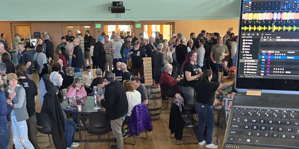 View from behind the decks at Stoutfest 2026: Serato on the laptop, a packed hall out front